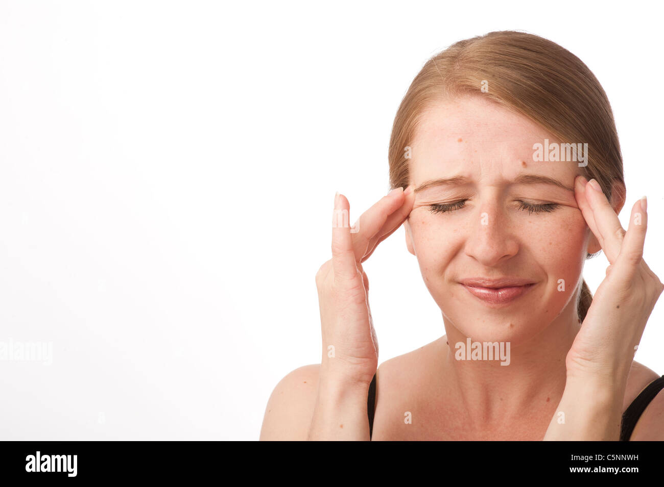eine junge kaukasischen Frau mit Kopfschmerzen Stirn reiben zur Linderung der Schmerzen, UK Stockfoto