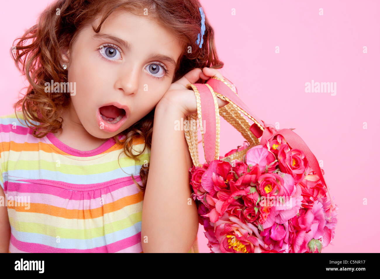 Kinder Mädchen halten Fashin Frühling rosa Blumen Tasche Sruprised Ausdruck Stockfoto