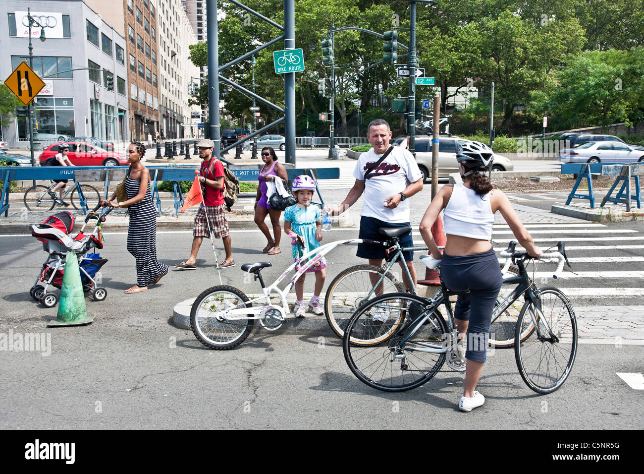 Kaukasische Familie mit Fahrrädern Kreuze Pfade mit schwarzen Familie zu Fuß auf der West Seite Waterfront Radweg New York City Stockfoto