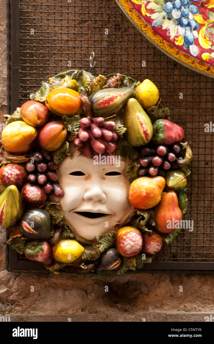 Eine Maske, die in Obst und Gemüse bekränzt ziert eine Wand in Orvieto Stockfoto