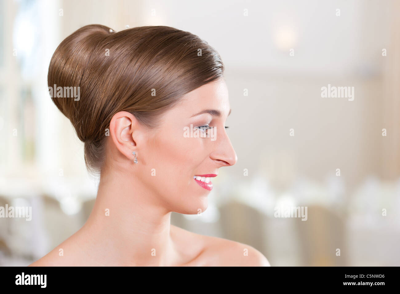 Lächelnde Braut mit gekämmtem Haar vor der Hochzeit Stockfoto