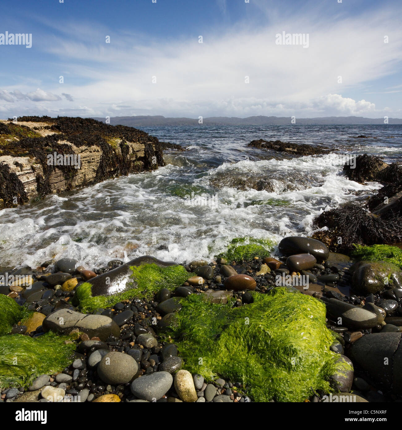 Wellen brechen über Algen bedeckt, Felsen und Geröll am Ufer des Loch ich, Glasnakille, Isle Of Skye, Schottland Stockfoto