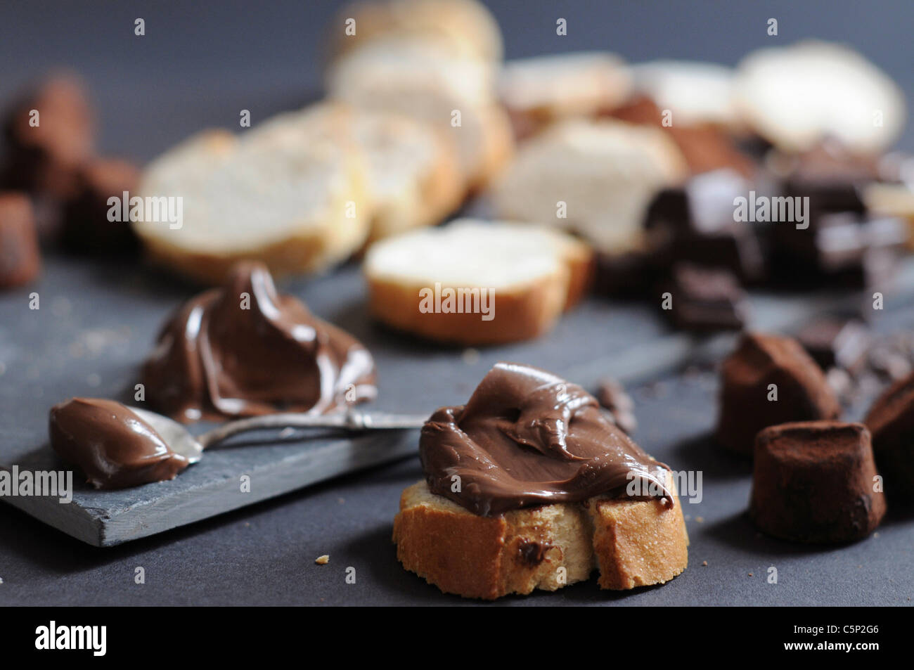 Scheiben Baguette mit Schokoladencreme, Schokoladenstückchen und Trüffeln, Cokoa Pulver Stockfoto