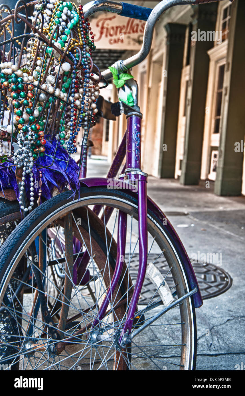 Fahrrad mit Karneval Perlen verziert gesperrt, um einen Beitrag über eine typische Straße der French Quarter in New Orleans. Stockfoto