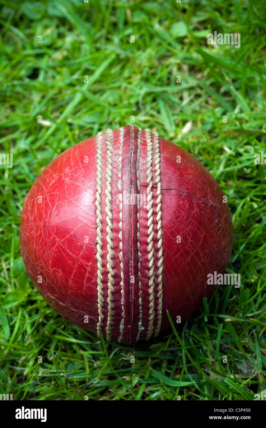 roten Cricketball auf dem grünen Rasen, CRICKET, BALL, rot, Naht, alte, abgenutzte, DISTRESSED, SPIN, Naht, englischen Rasen, Dave Podmore Stockfoto