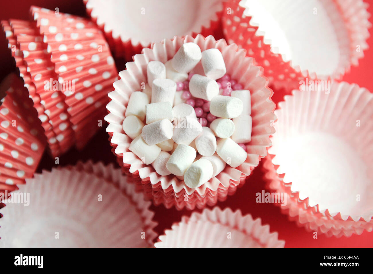 Rosa Muffin-Fällen mit weißen Punkten und Mini marshmallows Stockfoto