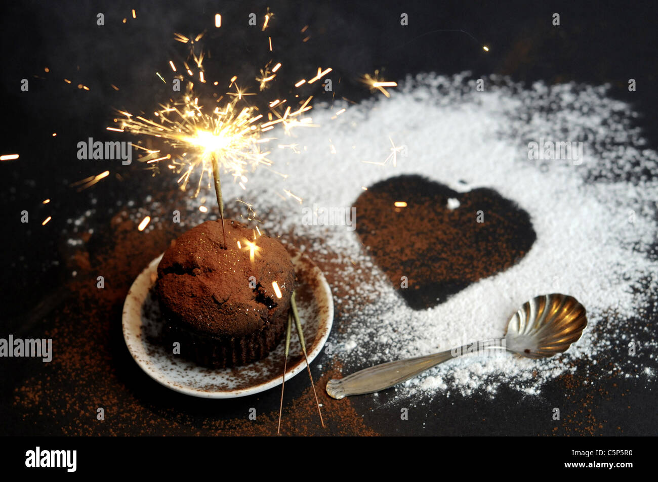 Kleine Schokoladen-Kuchen mit funkelnden Kerze Stockfoto