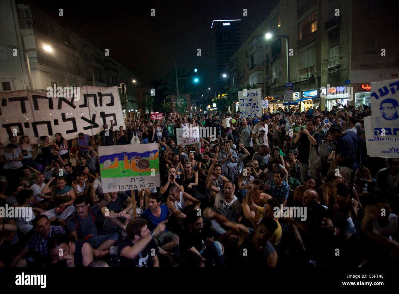 Israelis sitzen auf dem Boden bei einem Protest gegen steigende Immobilienpreise und sozialen Ungleichheiten in Tel Aviv Israel Stockfoto