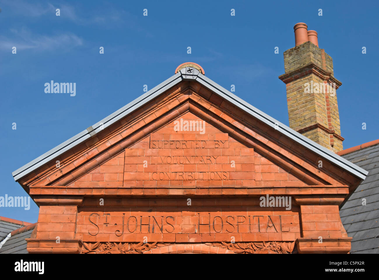 Aussenansicht des 19. Jahrhunderts St Johns Krankenhauses, mit Aufschrift "unterstützt durch freiwillige Beiträge", Twickenham, England Stockfoto
