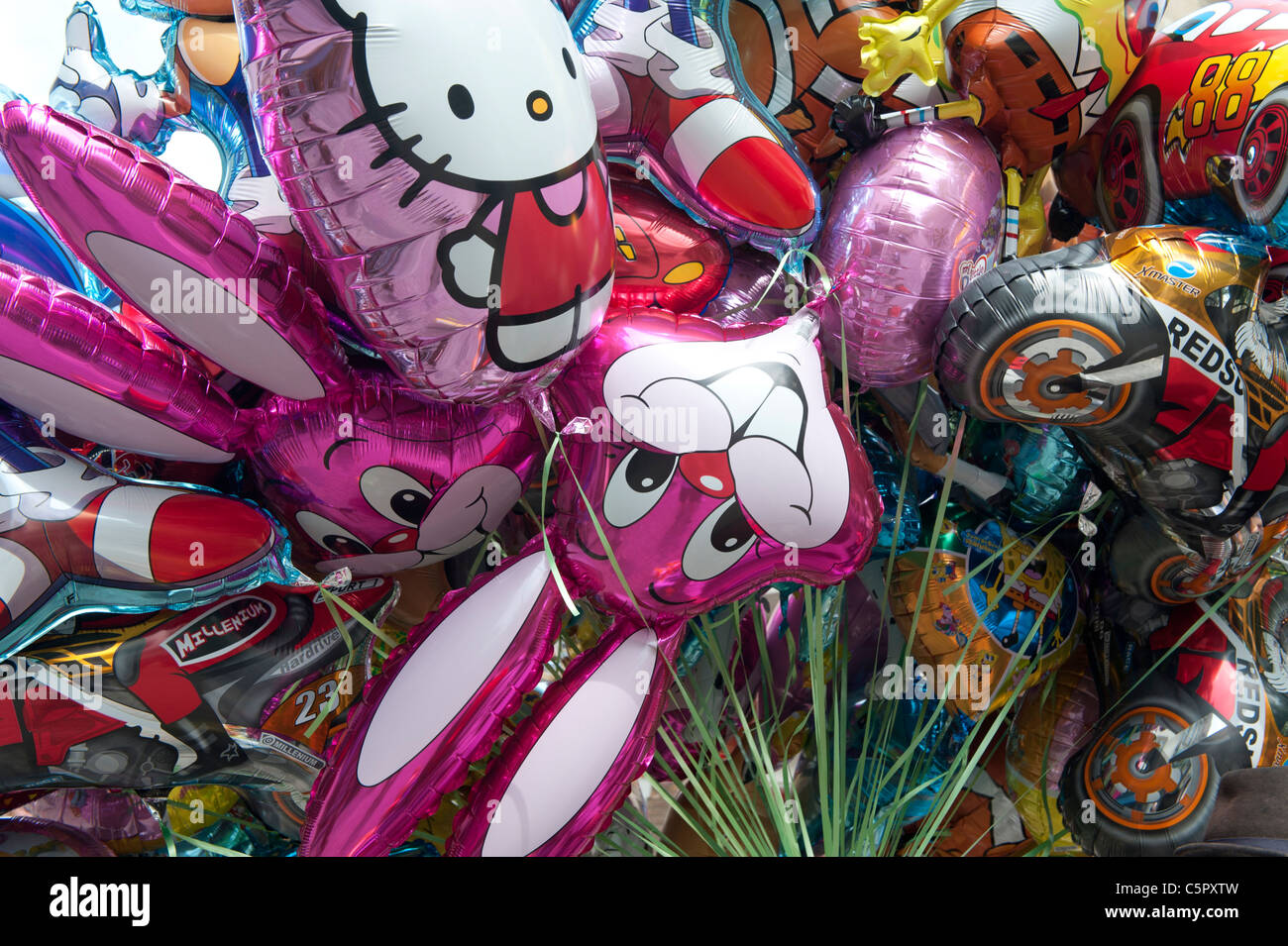 Ein paar aufblasbare Helium-Ballons mit Kinder Charakteren auf einer Straße in Truro, Conrwall verkauft. Stockfoto