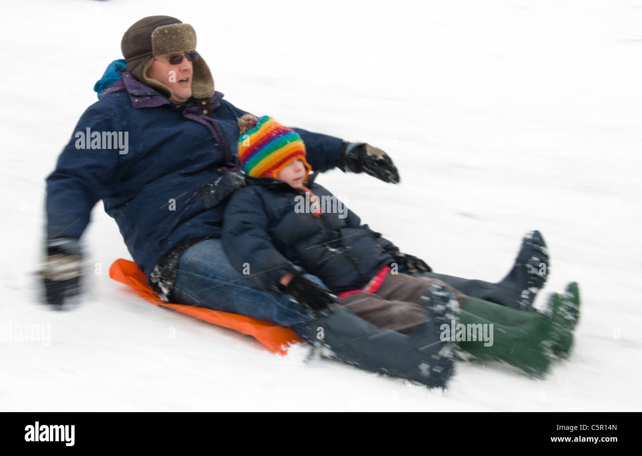Vater und Tochter genießen den Schnee auf Primrose Hill, London Stockfoto