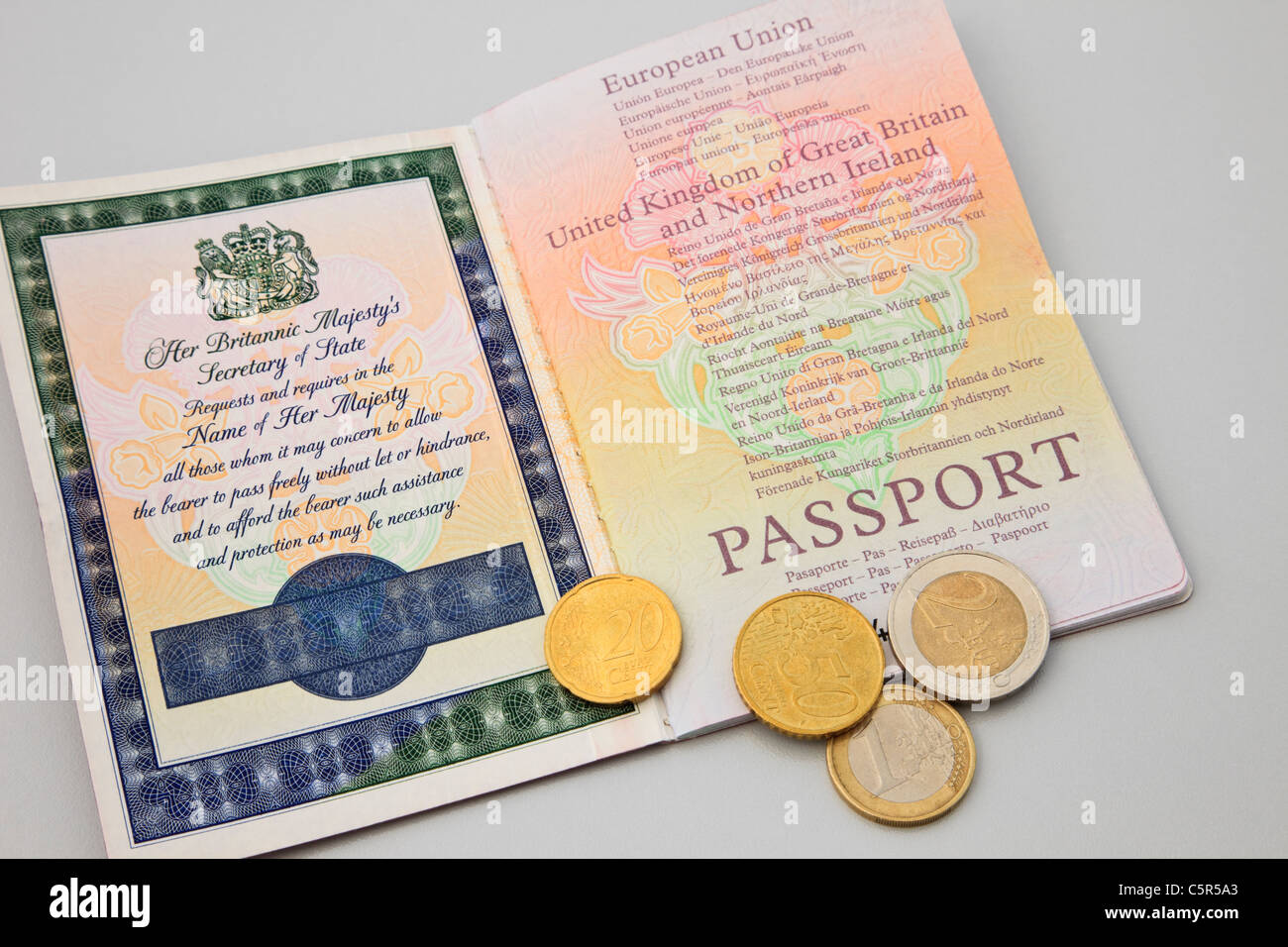 UK, Großbritannien. Ein britischer Pass zu öffnen, mit ein paar Euromünzen für Reisen in der Eurozone Stockfoto