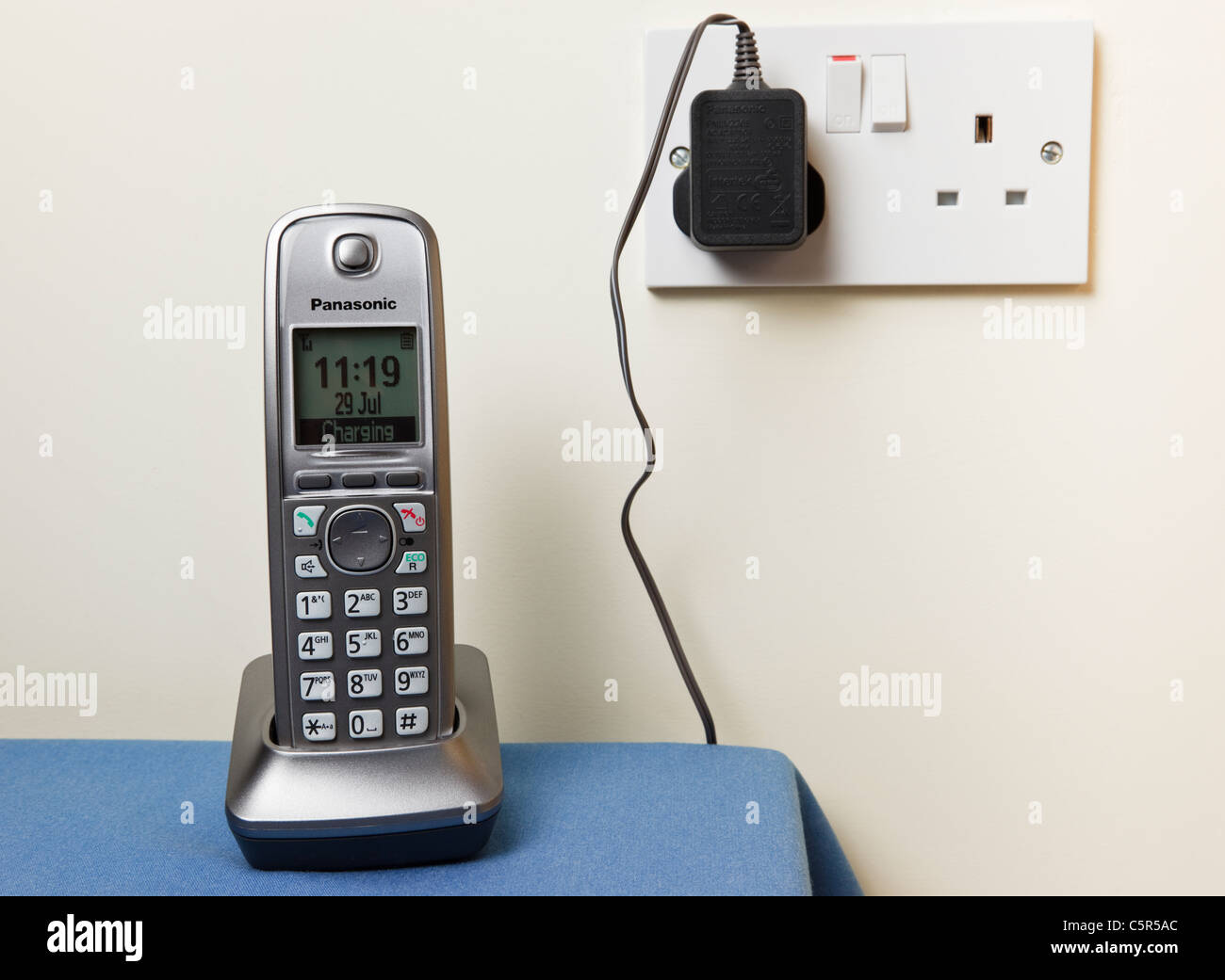 Panasonic moderne kabellose digitale Telefon Mobilteil Aufladen auf einem  Handy Ladegerät Basiseinheit angeschlossen an eine Steckdose an. England  Großbritannien Großbritannien Stockfotografie - Alamy