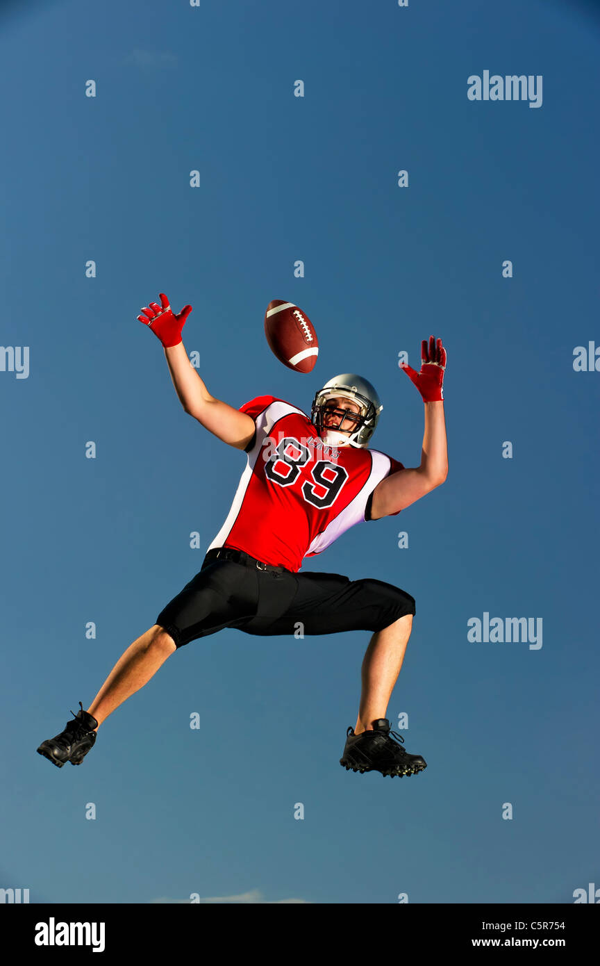 American-Football-Spieler springt zu fangen. Stockfoto