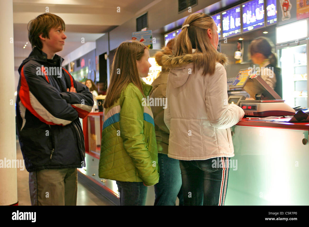 Jugendliche, die Schlange, um Süßigkeiten in einem Kino zu bekommen, bevor der Film beginnt Stockfoto