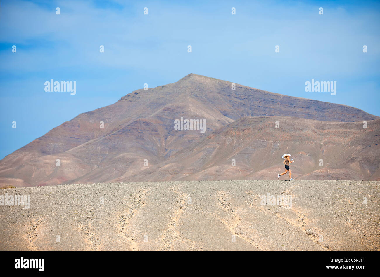 Eine lange Strecke weibliche Läufer durch eine bergige Wüste Joggen. Stockfoto