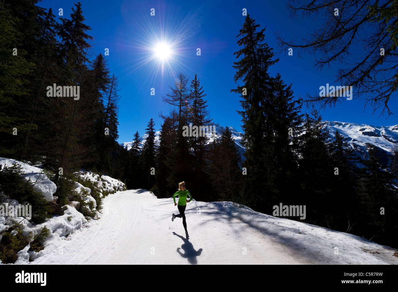 Ein Jogger läuft auf verschneiten Bergen. Stockfoto