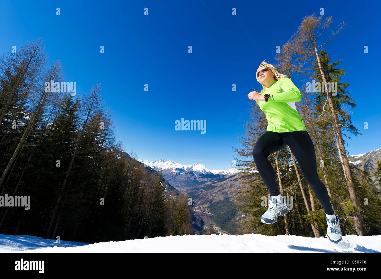 Eine Frau, Joggen in verschneiten Bergen. Stockfoto