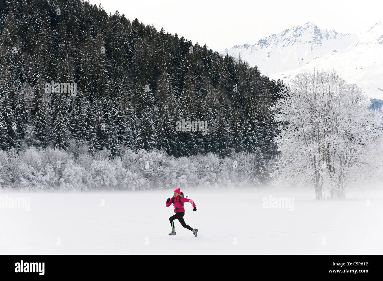 Ein Läufer sprinten durch eine gefrorene Winterlandschaft. Stockfoto