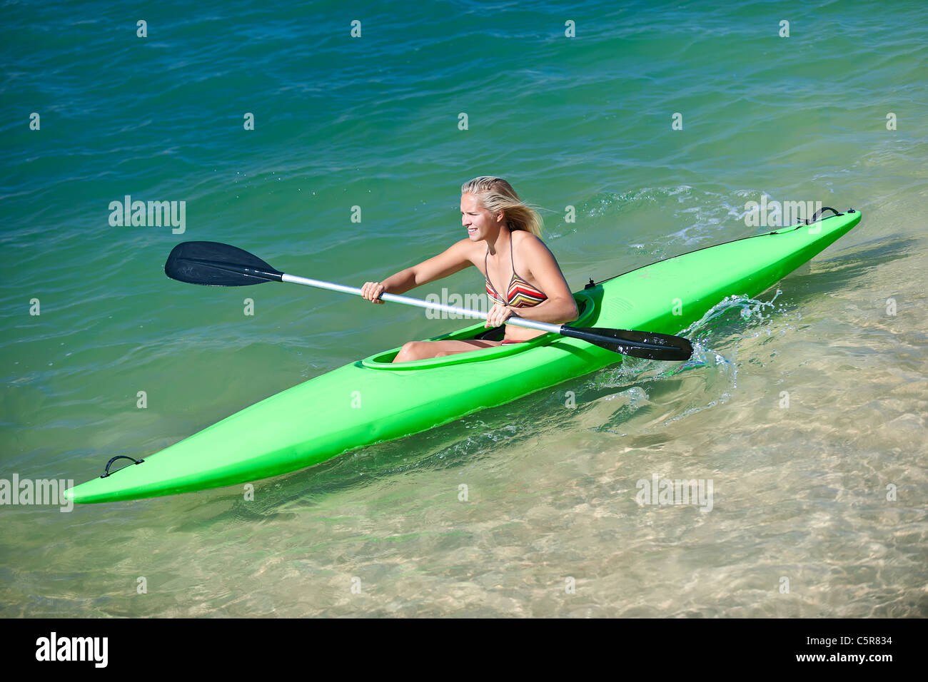 Eine Frau paddelt ihr Kanu an einem sonnigen Tag. Stockfoto