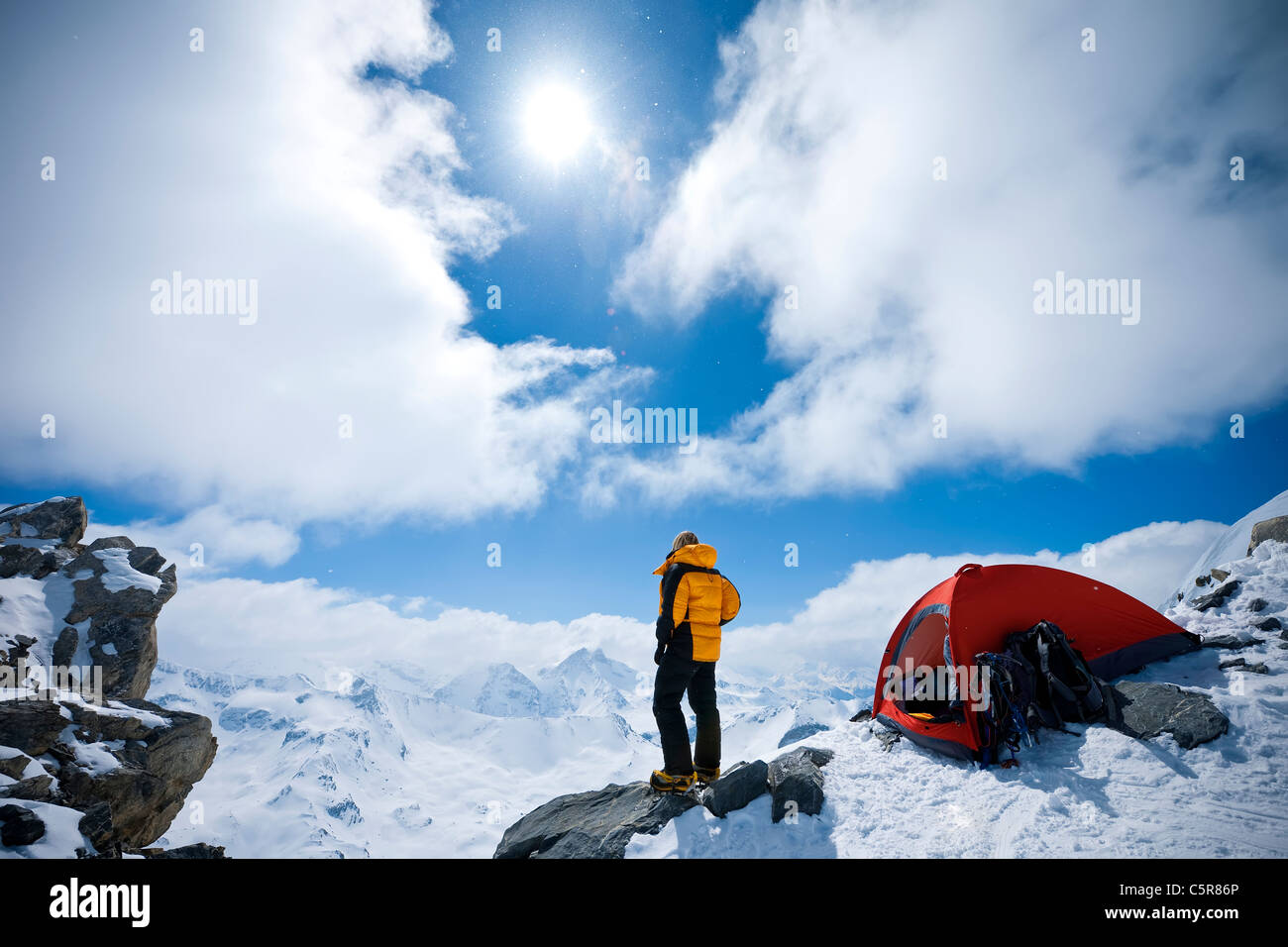 Ein Bergsteiger blickt auf schneebedeckten Berge. Stockfoto