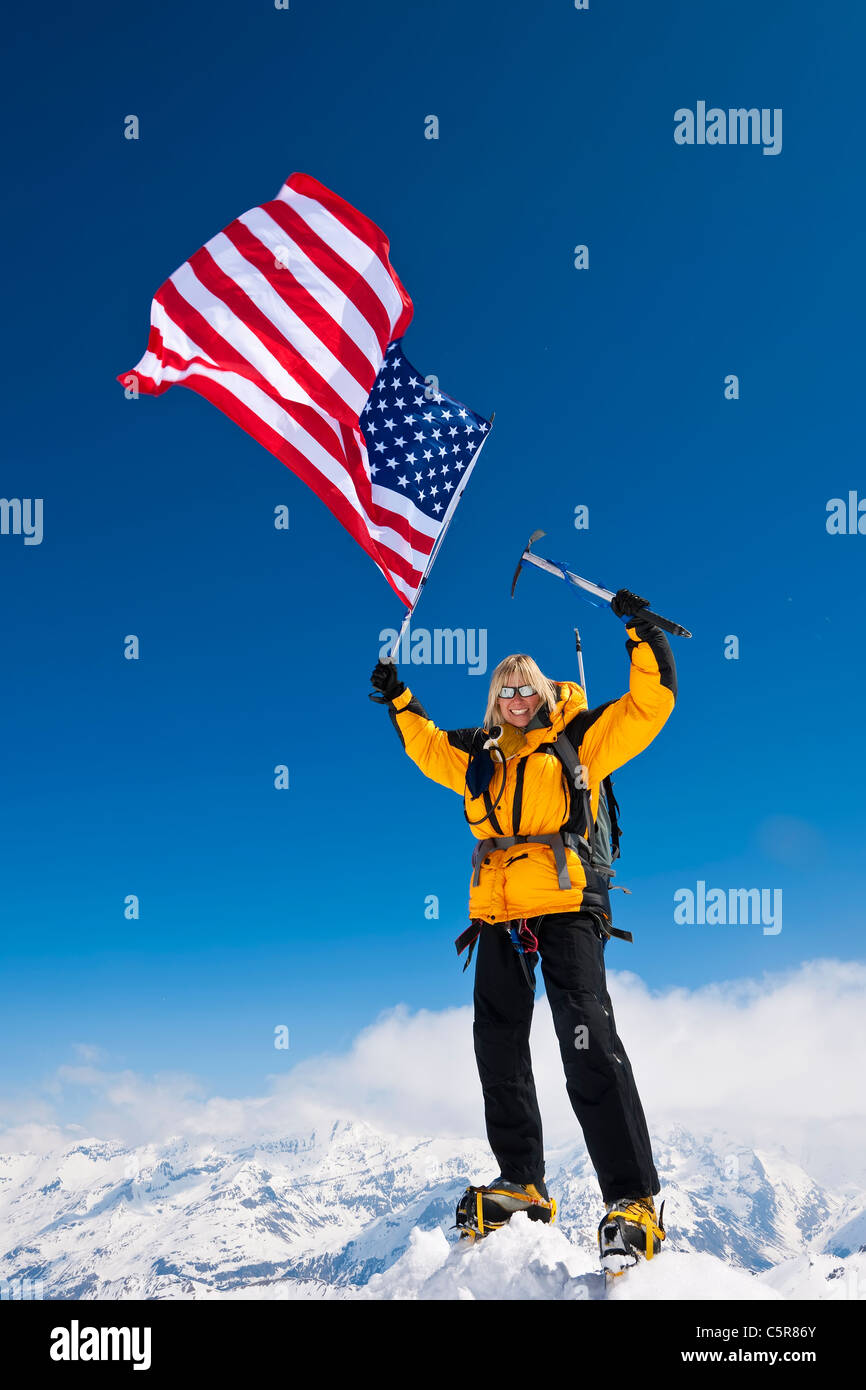 Bergsteiger feiert am Anfang der Welt fliegen, den Sternen und Streifen Stockfoto