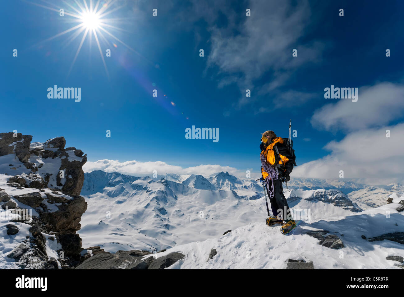 Ein Bergsteiger über die Gipfel und Wolken befasst sich mit der tollen Aussicht. Stockfoto