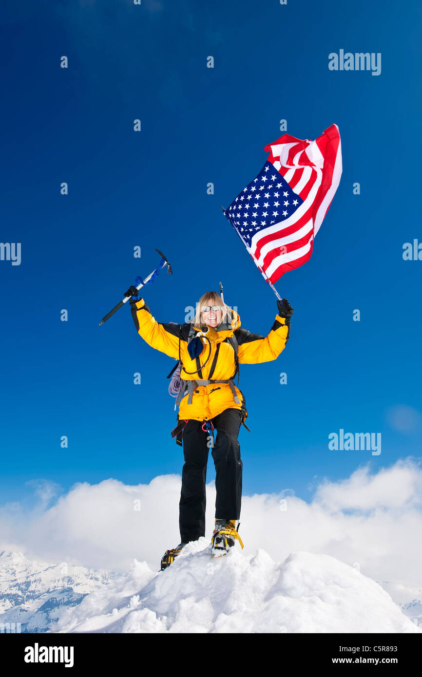 Ein Bergsteiger feiert vom fliegen, den Sternen und Streifen auf dem Dach der Welt. Stockfoto