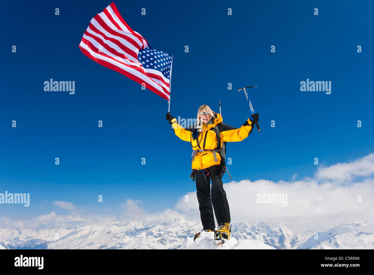 Bergsteiger feiert am Gipfel fliegen, den Sternen und Streifen. Stockfoto