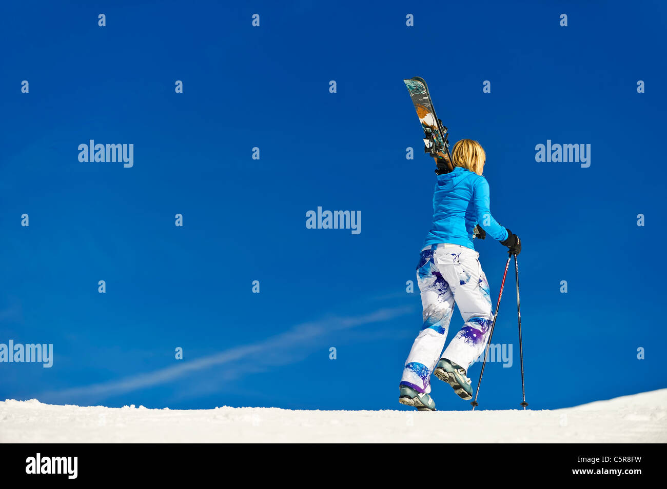 Eine Skifahrerin zu Fuß entlang der Piste. Stockfoto