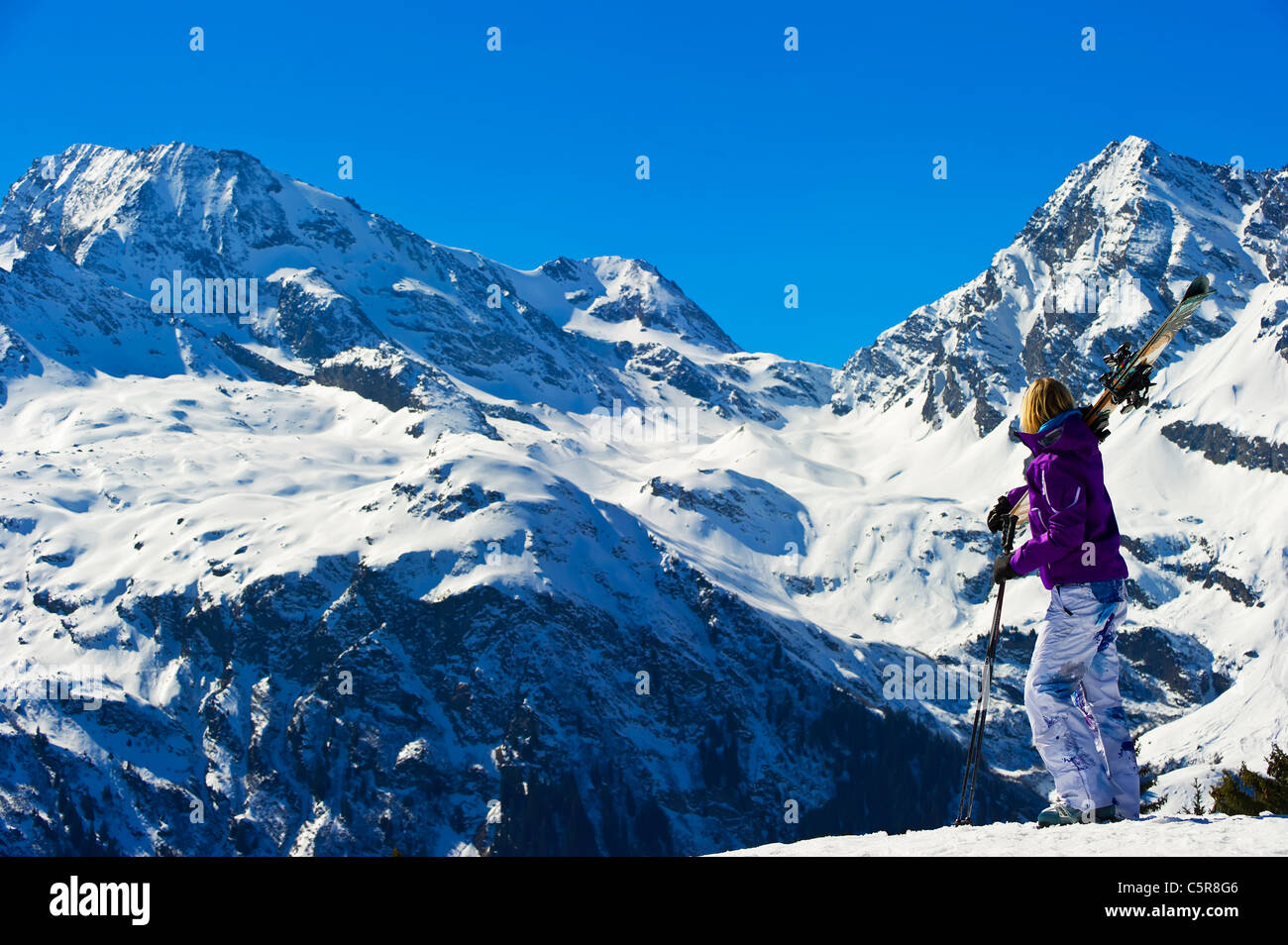 Ein Skifahrer einen Blick auf eine atemberaubende schneebedeckten Winterbergen. Stockfoto