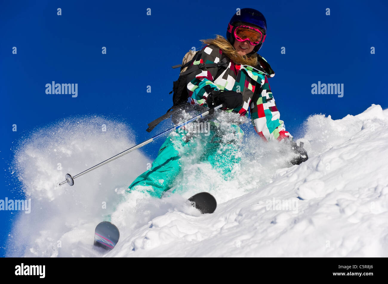 Ein glücklicher Skifahrer Ski durch frischen Pulverschnee. Stockfoto