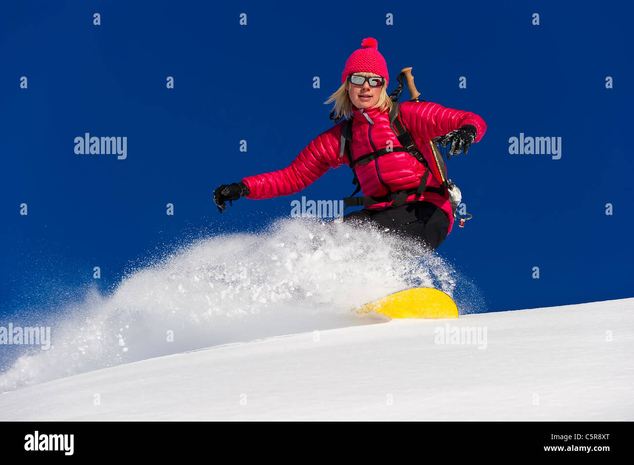 Ein Snowboarder reitet tief frischen Pulverschnee mit Geschwindigkeit. Stockfoto