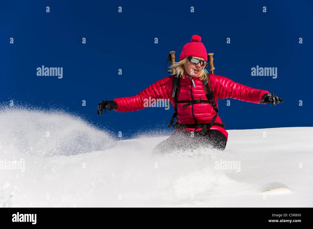 Ein ausgewogenes Snowboarder fahren schnell durch den frischen Pulverschnee. Stockfoto