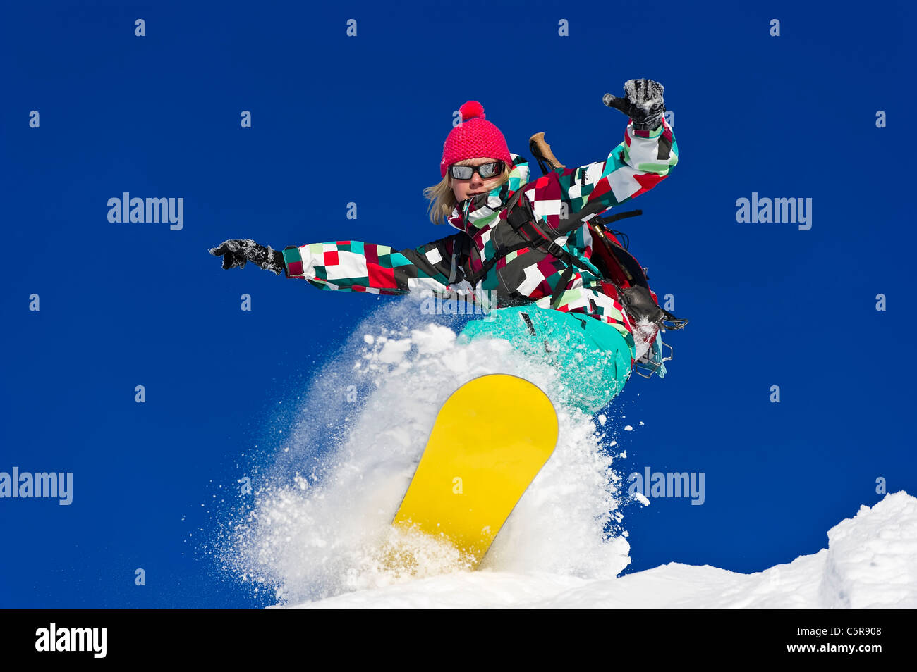 Weiblichen Snowboarder fährt hart durch tief frischen Pulverschnee. Stockfoto