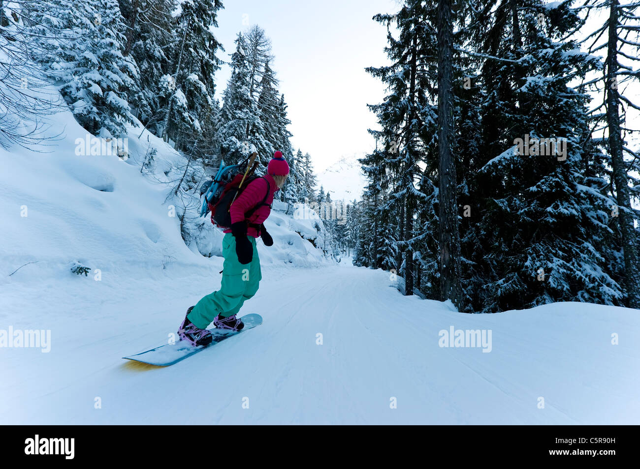 Ein Snowboarder Fahrten Zuhause wie die Sonne untergeht. Stockfoto