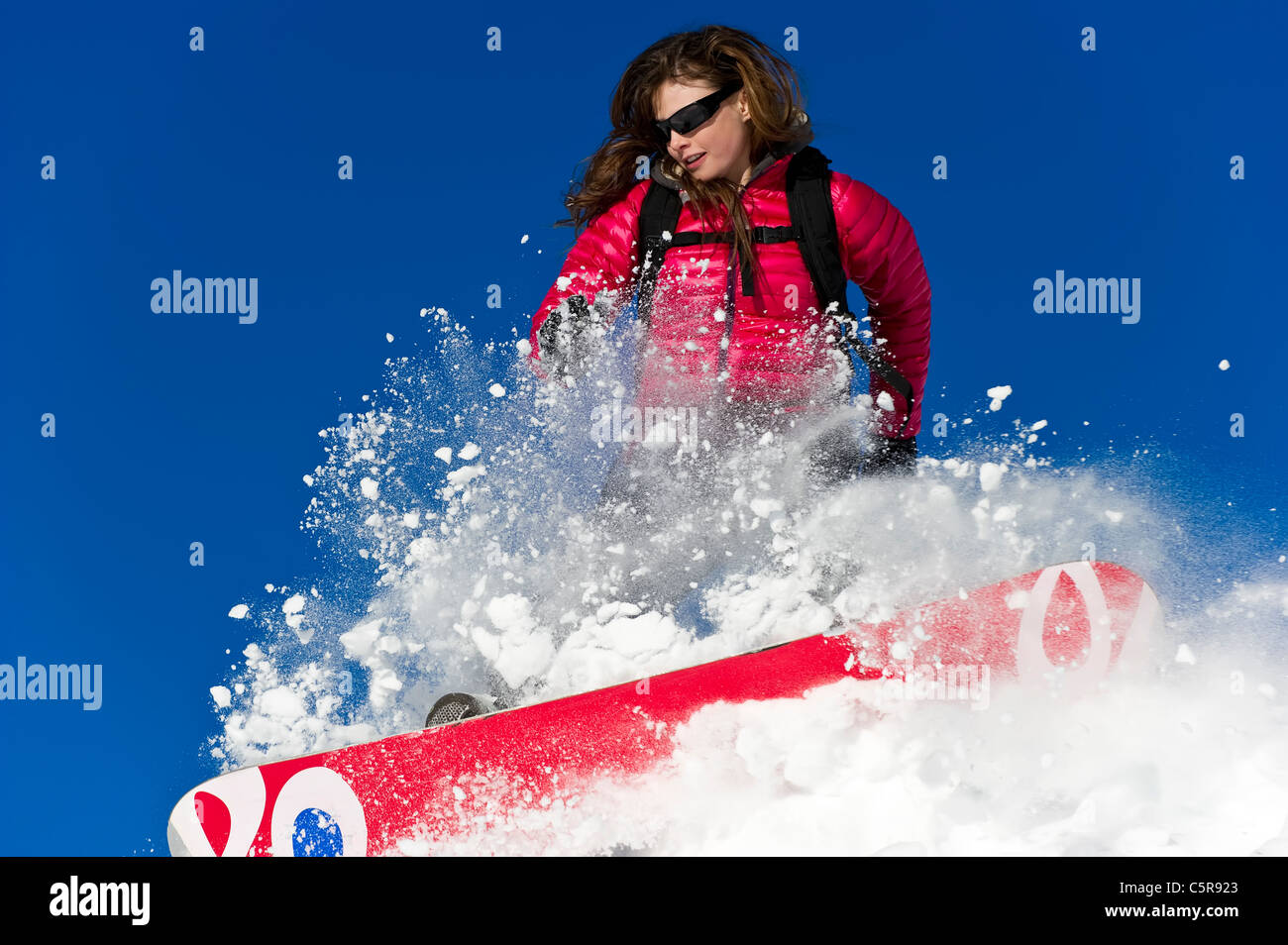 Weiblichen Snowboarder fährt hart durch frischen Pulverschnee. Stockfoto