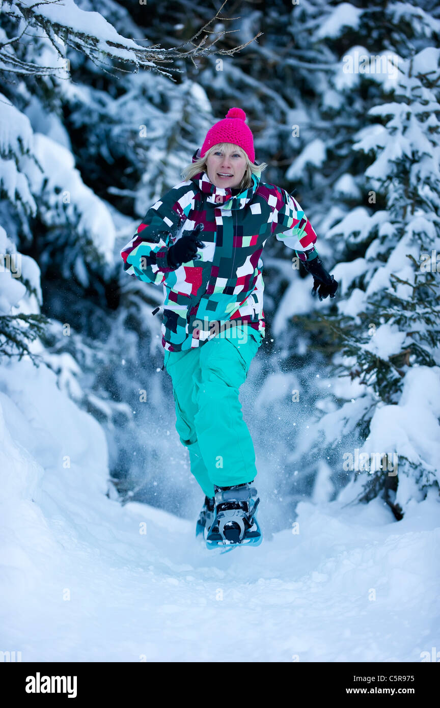 Eine Frau, die Schneeschuhwanderung durch den verschneiten Wald. Stockfoto