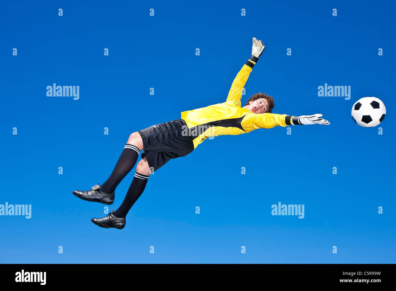 Der Torwart erstreckt sich zu versuchen, einen Ball zu retten. Stockfoto