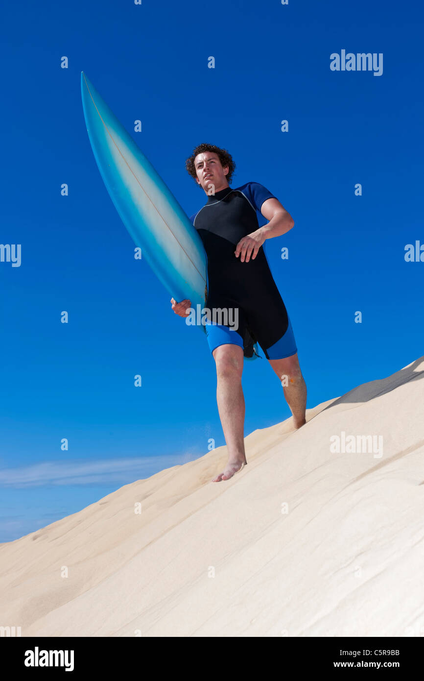 Surfer zu Fuß entlang der Sanddünen Köpfe in Richtung Ozean. Stockfoto