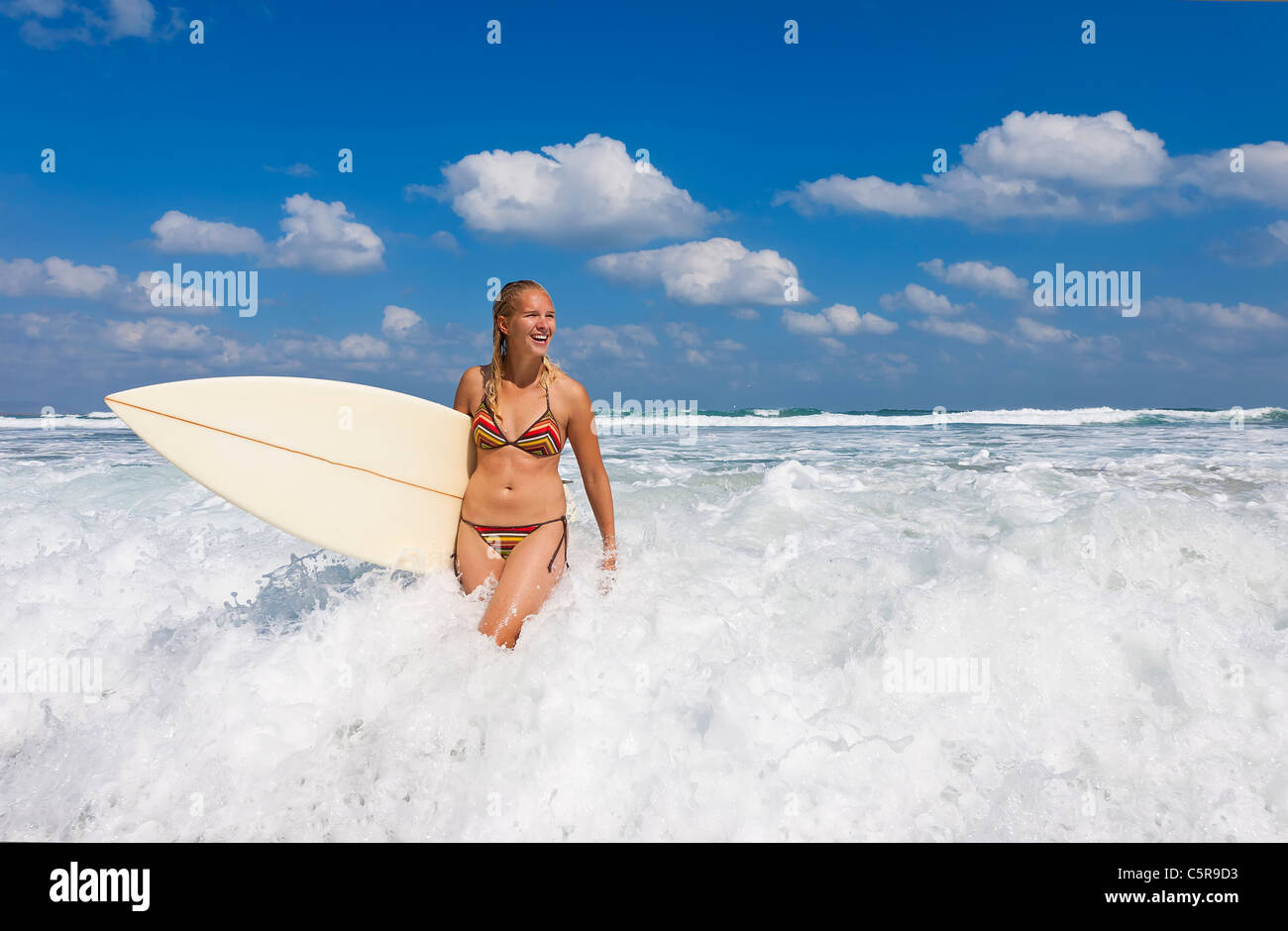 Ein junge blonde Surfer ergibt sich aus dem Ozean. Stockfoto