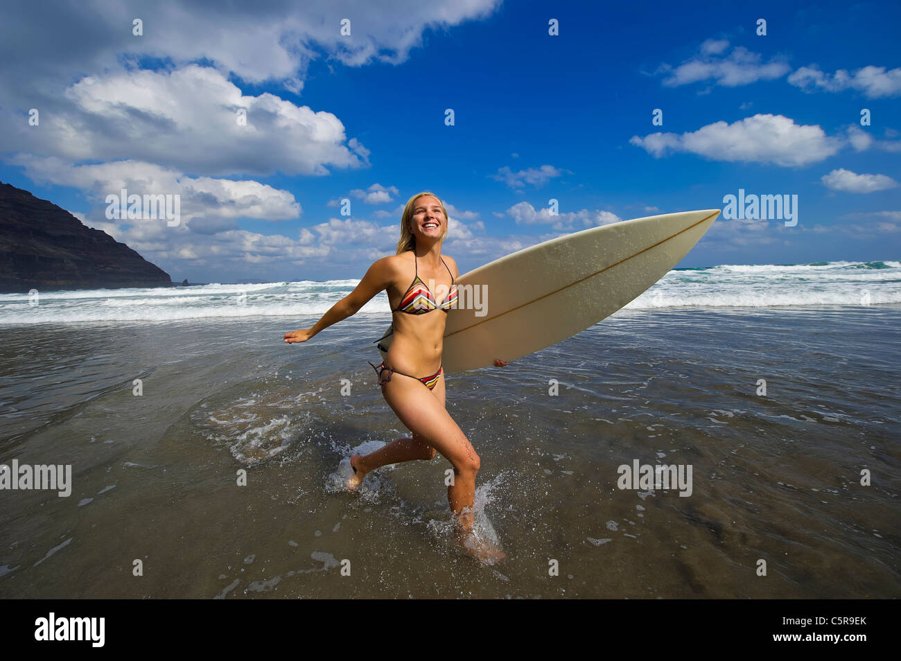 Eine junge blonde Surfer Mädchen Spaß in den Wellen des Ozeans. Stockfoto