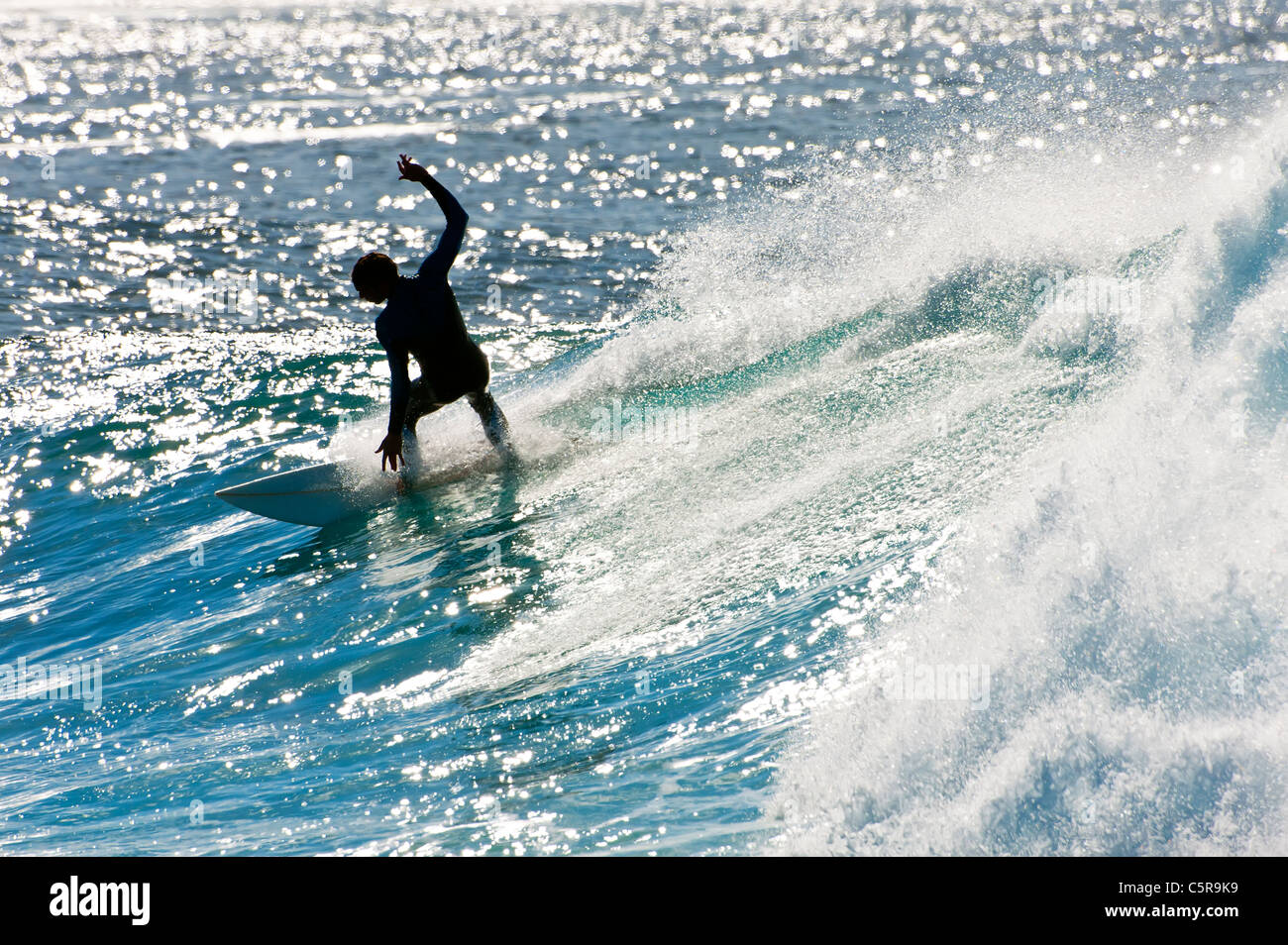 Ein Surfer eine funkelnde Welle schnitzen. Stockfoto
