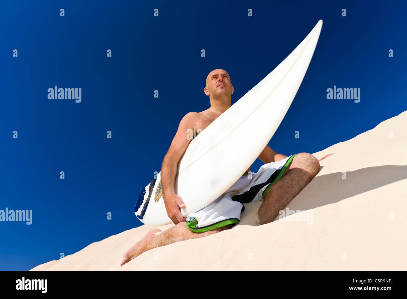Surfer auf Düne sitzen. Stockfoto
