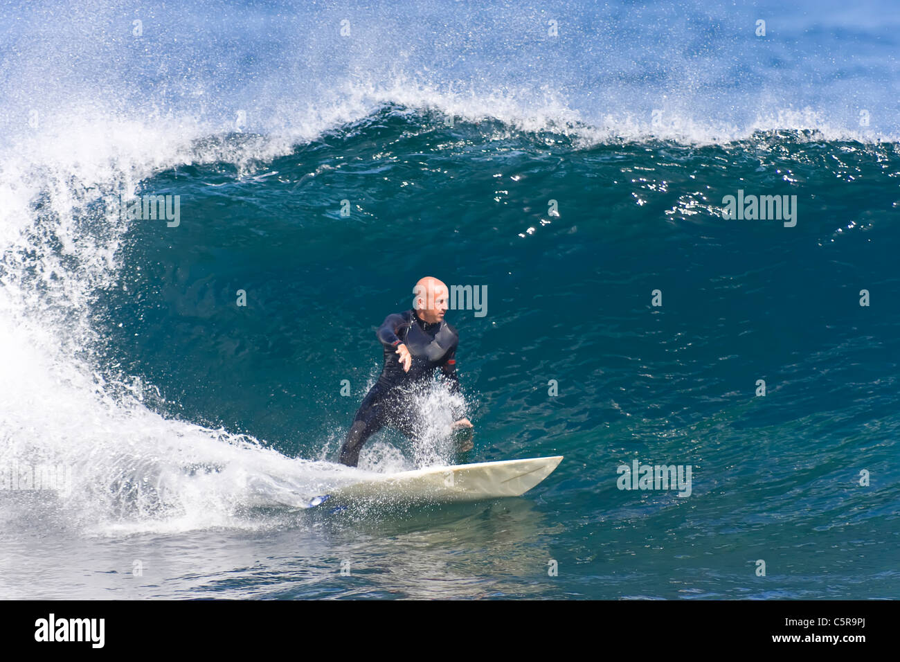 Surfer schnitzt eine brechende Welle Geschwindigkeit. Stockfoto
