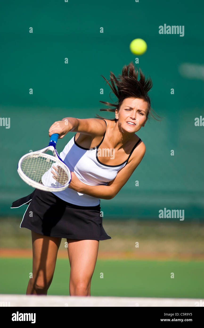 Tennisspieler zerschlägt Ball über Netz. Stockfoto