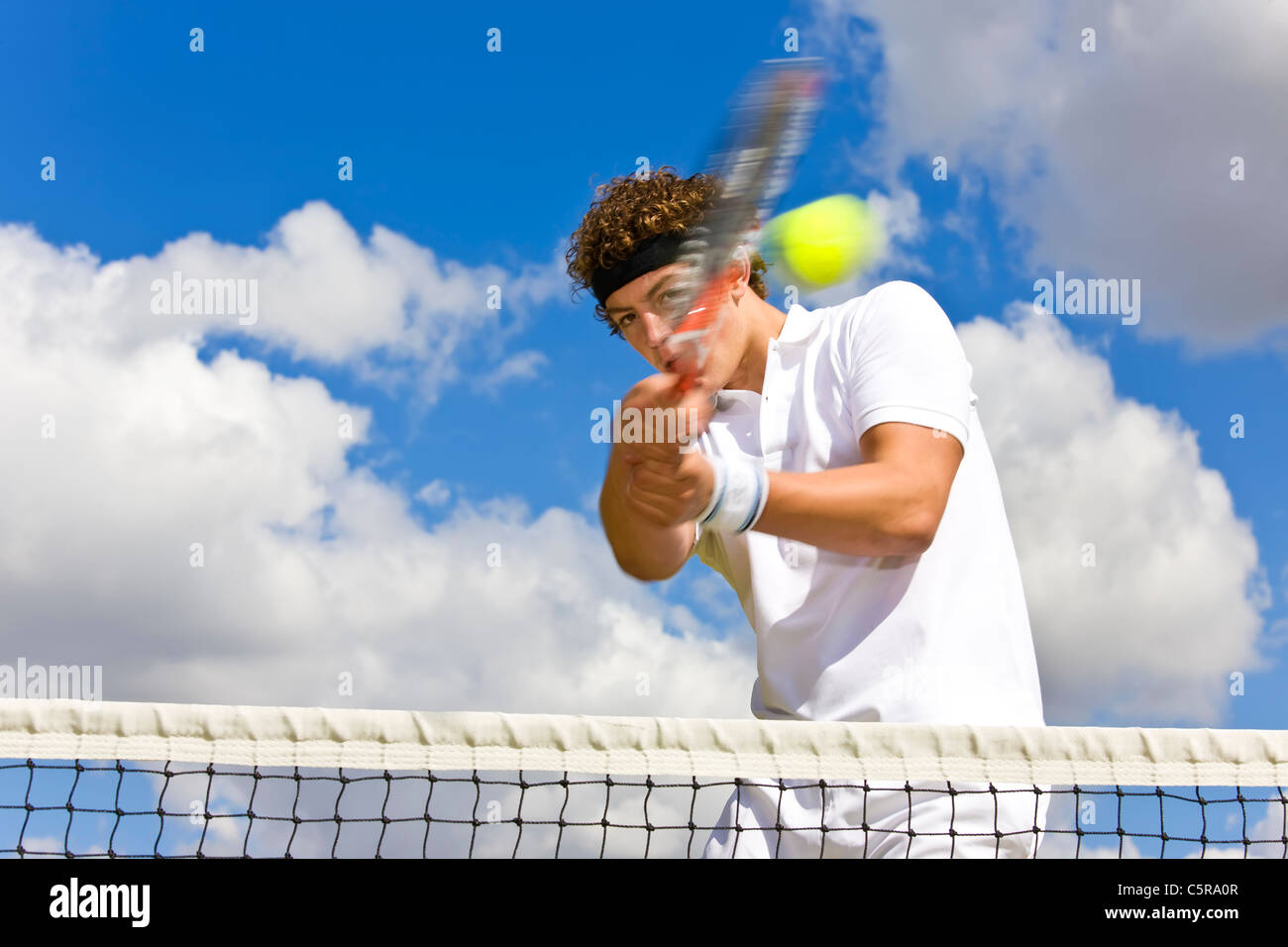 Ein Tennisspieler kehrt Ball am Netz. Stockfoto