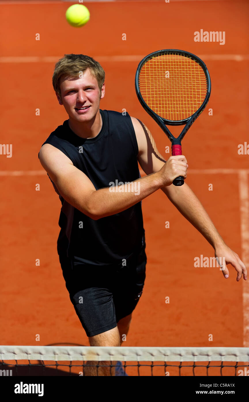 Ein Tennisspieler lächelt, als er bereit bekommt, volley Ball. Stockfoto