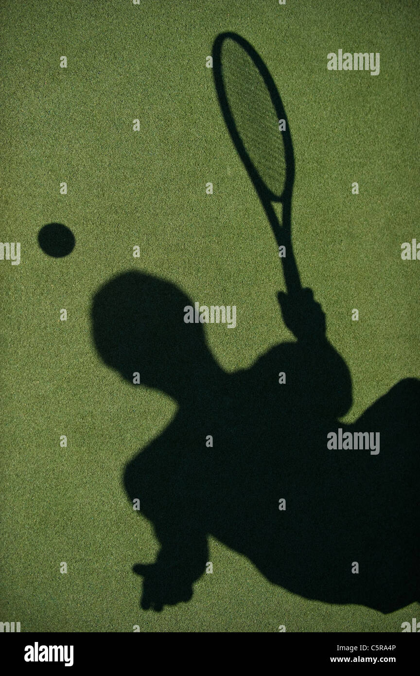 Die Silhouette der Tennisspielerin auf Platz. Stockfoto