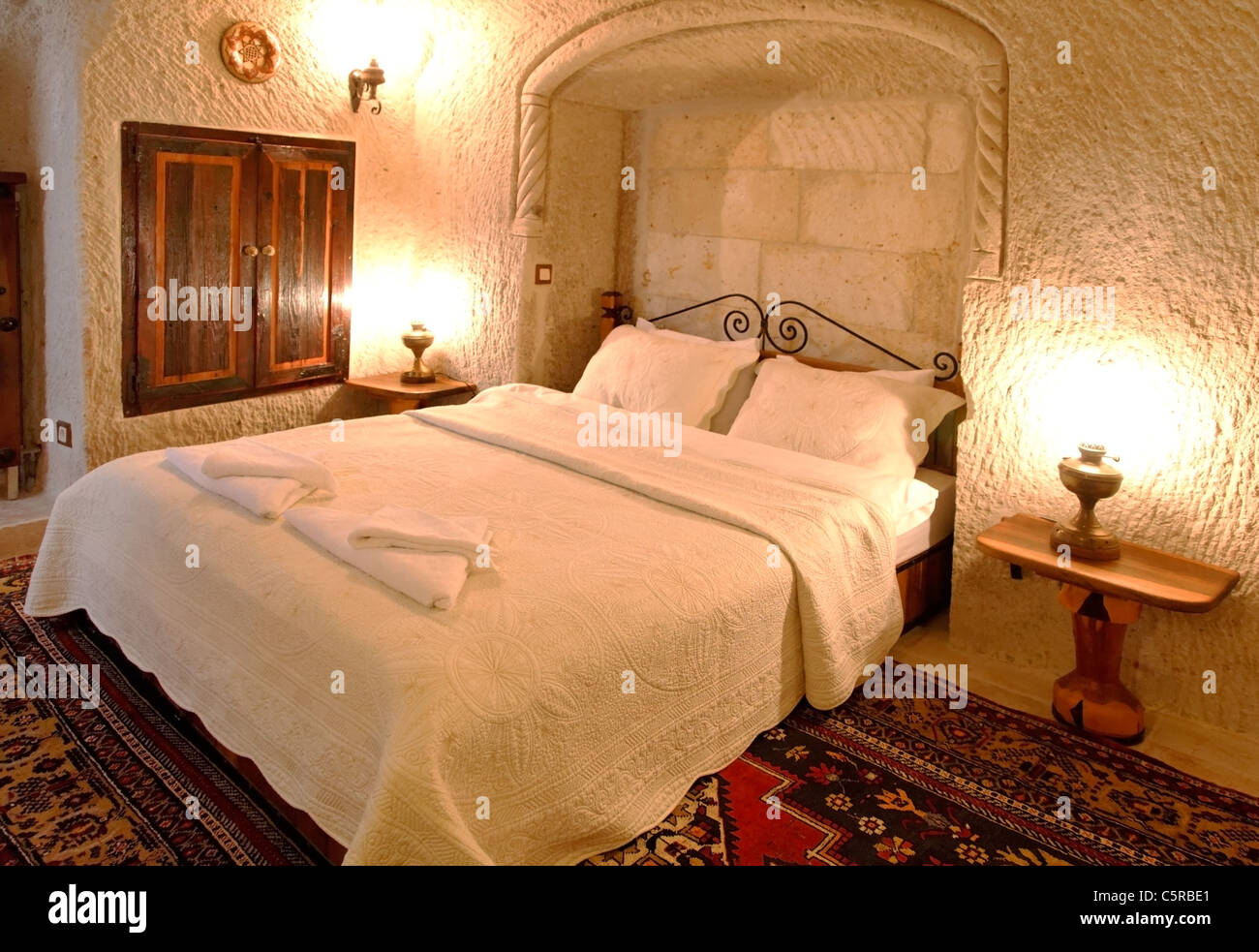 architektonischen Innenraum Detaillierung der Schlafzimmer mit Messing verzierten Kopfteil, weiße Bettwäsche und Kissen, eingelegten Wandschrank Stockfoto